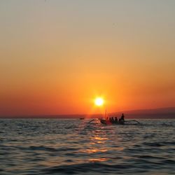 Boat sailing in sea at sunset