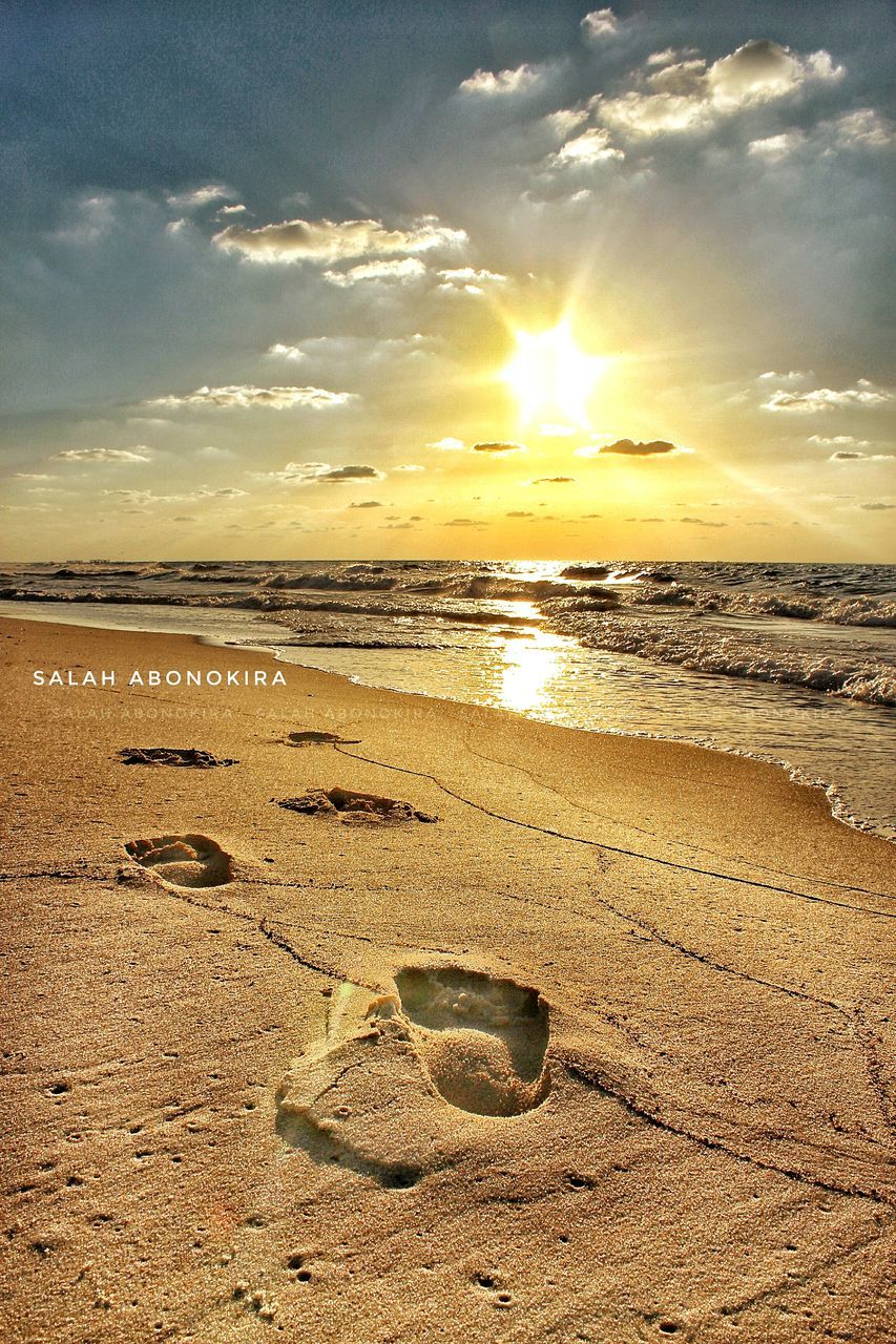 VIEW OF CALM BEACH AGAINST SUNSET SKY