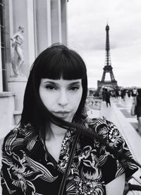 Portrait of woman standing against tour eiffel