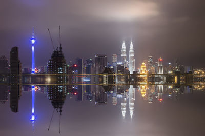 View of illuminated urban skyline against sky at dusk