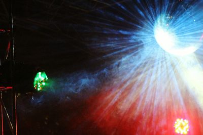 Close-up of illuminated lighting equipment against sky at night