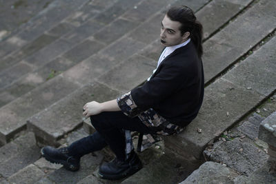 High angle view of thoughtful young man sitting on steps 