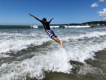 Man surfing in sea against sky