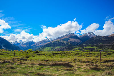 Scenic view of landscape and mountains against blue sky