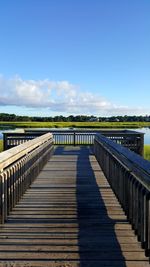 Bridge over calm blue sea against sky