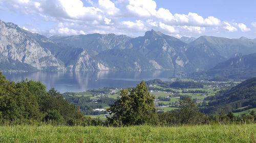 Scenic view of lake by mountains against sky