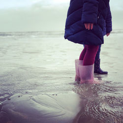 Low section of child standing on beach