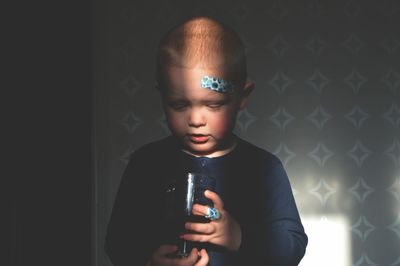 Boy holding drink while standing at home