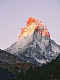 Low angle view of snowcapped mountain against clear sky