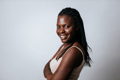 Portrait of laughing young woman against gray background