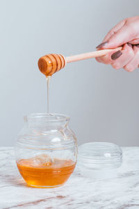 Cropped hand of person pouring into glass