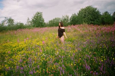 Woman standing on field against sky