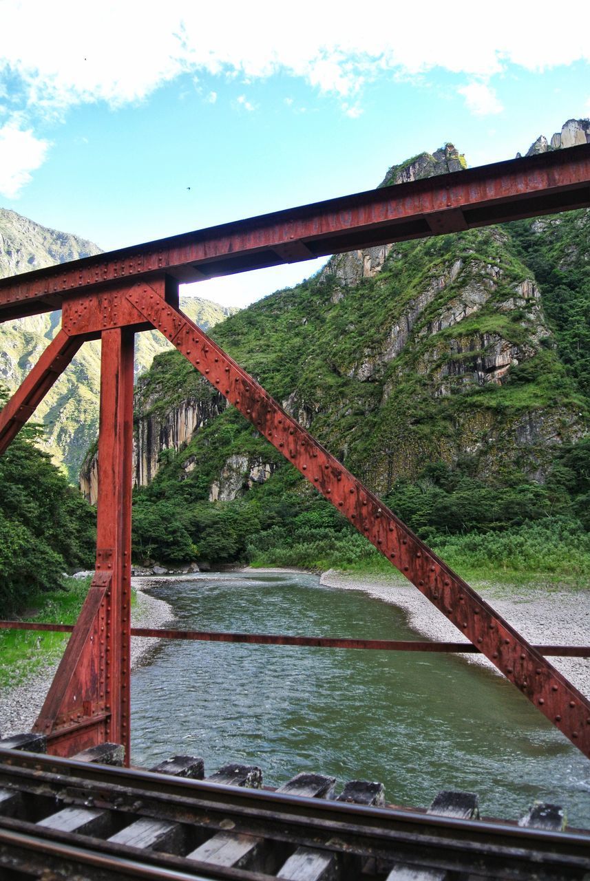 BRIDGE OVER RIVER BY TREES AGAINST SKY