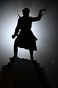 Low angle view of silhouette man standing on rock