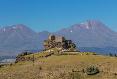 Built structure on mountain against blue sky