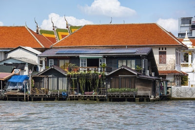 Houses by river against sky