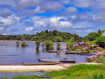 Scenic view of river by trees against sky