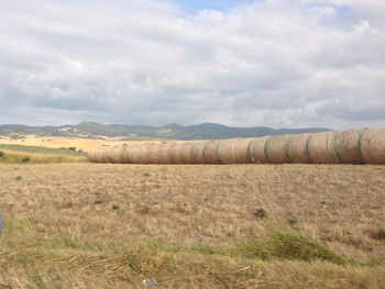 Hay bales on field against sky