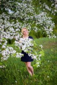 Portrait of happy girl with flowers on tree