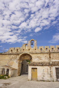 Low angle view of historical building against cloudy sky
