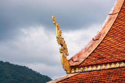 Low angle view of traditional building on roof against sky