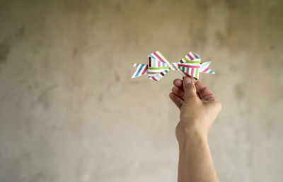 Close-up of hand holding paper against blurred background