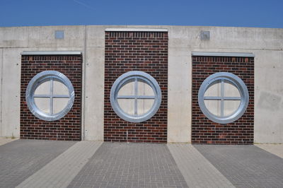 Closed doors on wall against clear sky