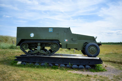 Old truck on field against sky