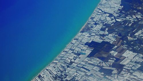 Aerial view of cityscape against blue sky