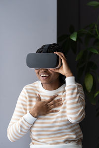 Female in vr goggles laugh shocked with virtual reality simulation testing gaming equipment at home