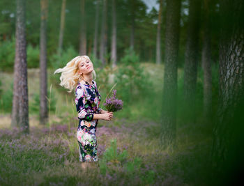 Portrait of woman standing at lavender field