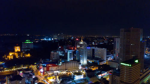 High angle view of illuminated buildings against sky at night