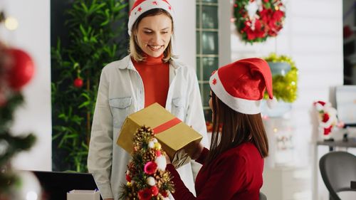 Portrait of young woman holding christmas tree