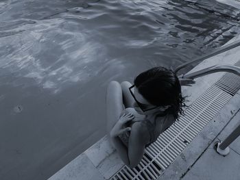 High angle view of young woman sitting at poolside