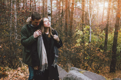 Smiling couple standing in forest