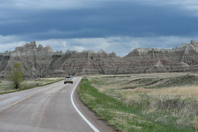 Car on road by mountain against sky