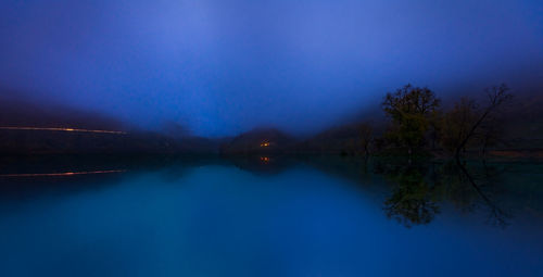 Scenic view of lake against blue sky at night