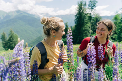 Two women friends bonding while hiking at the mountains in summer.