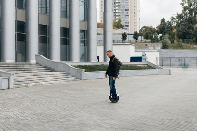 Man riding fast on electric unicycle on city street. mobile portable individual transportation