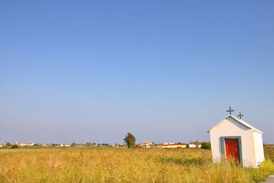 Trees on field against clear sky