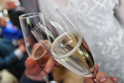 Cropped hands holding champagne flutes at wedding