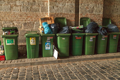 Row of garbage bin against brick wall