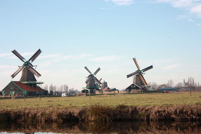 Traditional windmill on field against sky