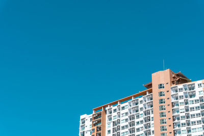 Low angle view of buildings against clear blue sky