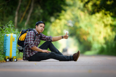 Young man sitting on road