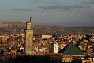 Mosque against buildings and mountains