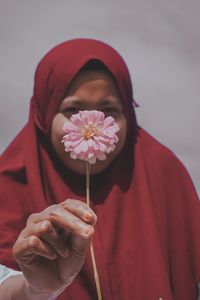 Portrait of a woman holding red flower