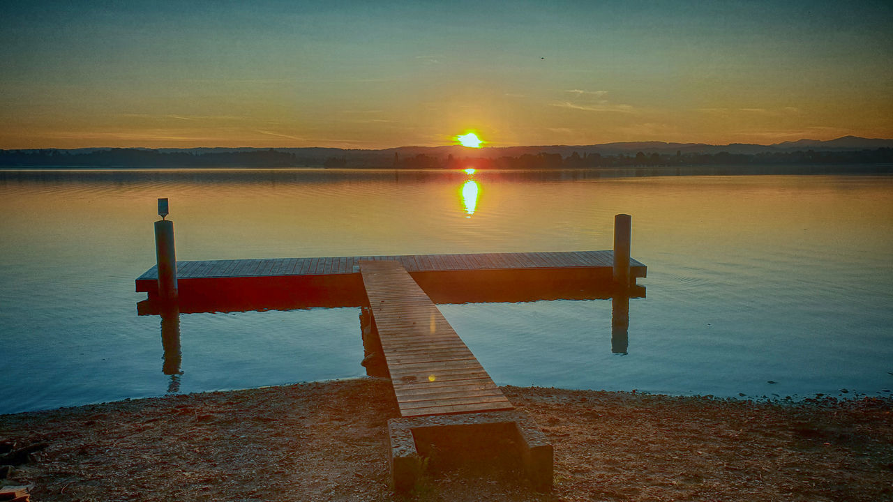 PIER OVER LAKE AGAINST SKY AT SUNSET