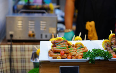 Barbecue sausage grilled with tomato herb and spices put in white plate for sale in dining festival