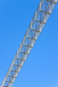 Low angle view of crane against clear blue sky